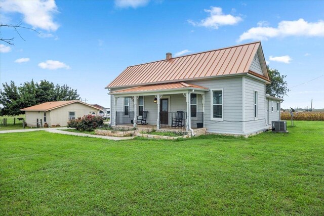 17205 County Line Rd, Elgin, TX 78621 - view of front of property featuring a standing seam roof, a porch, a front yard, a metal roof, and a chimney
