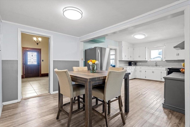 17205 County Line Rd, Elgin, TX 78621 - dining room featuring ornamental molding, light wood-style floors, a wainscoted wall, and a chandelier