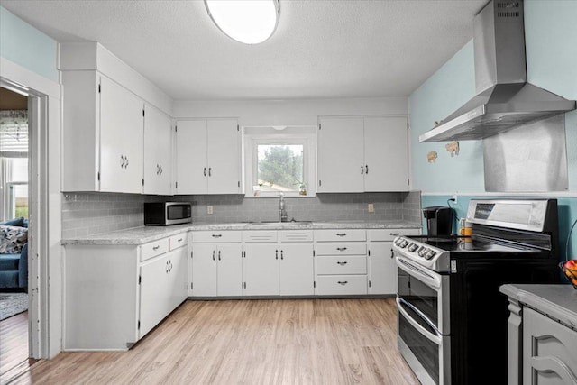 17205 County Line Rd, Elgin, TX 78621 - kitchen with wall chimney exhaust hood, appliances with stainless steel finishes, white cabinetry, decorative backsplash, and a textured ceiling