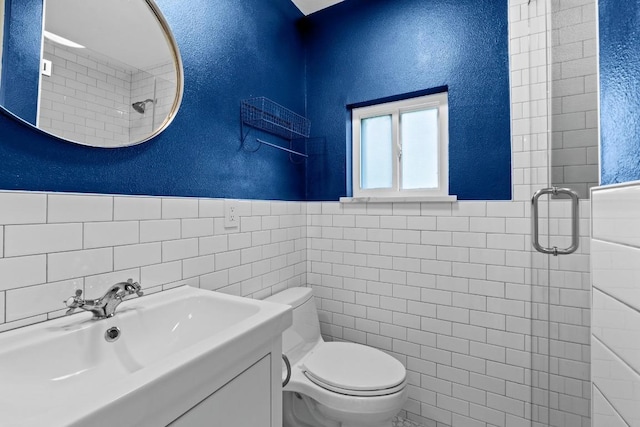 1701 Brentwood St, Austin, TX 78757 - bathroom with tile walls, tiled shower, a wainscoted wall, a textured wall, and vanity