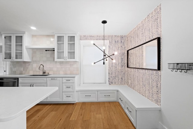1701 Brentwood St, Austin, TX 78757 - kitchen with a chandelier, white cabinets, light wood-type flooring, decorative backsplash, and light countertops