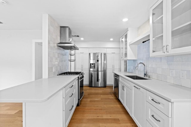 1701 Brentwood St, Austin, TX 78757 - kitchen featuring stainless steel appliances, wall chimney range hood, a peninsula, backsplash, and light countertops