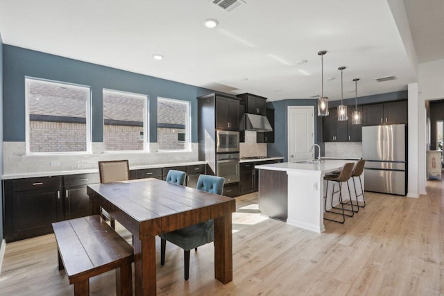 807 Arrowhead Ranch Blvd, Dripping Springs, TX 78620 - kitchen with stainless steel appliances, tasteful backsplash, ventilation hood, light countertops, and a center island with sink
