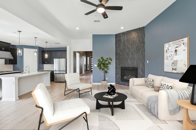 807 Arrowhead Ranch Blvd, Dripping Springs, TX 78620 - living area featuring light wood-type flooring, ceiling fan, a premium fireplace, and recessed lighting