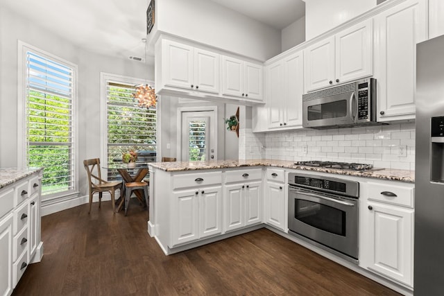 7800 SW Pkwy Unit 610, Austin, TX 78735 - kitchen featuring appliances with stainless steel finishes, decorative backsplash, dark wood-style floors, and white cabinetry