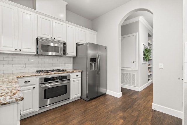 7800 SW Pkwy Unit 610, Austin, TX 78735 - kitchen featuring stainless steel appliances, white cabinetry, dark wood-type flooring, backsplash, and light stone countertops