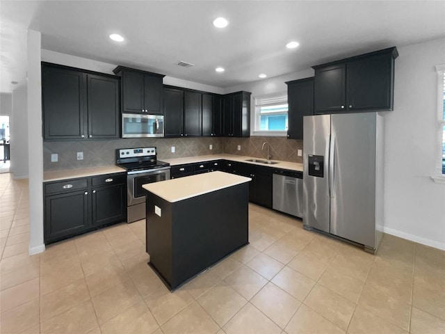 312 La Escalera Dr, Leander, TX 78641 - kitchen with appliances with stainless steel finishes, dark cabinetry, light countertops, decorative backsplash, and recessed lighting
