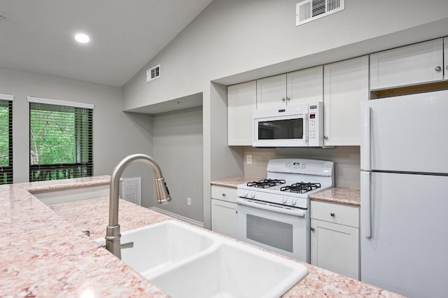 3839 Dry Creek Dr Unit 207, Austin, TX 78731 - kitchen with white appliances, white cabinets, light countertops, lofted ceiling, and recessed lighting