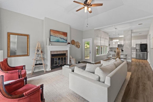 2134 Cervin Blvd, Austin, TX 78728 - living area with wood finished floors, a ceiling fan, a fireplace, and a chandelier