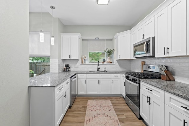 2134 Cervin Blvd, Austin, TX 78728 - kitchen featuring stainless steel appliances, white cabinets, light wood-type flooring, and tasteful backsplash