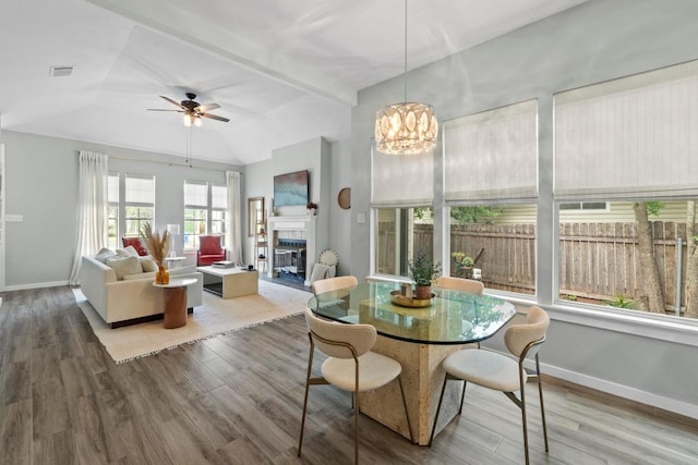 2134 Cervin Blvd, Austin, TX 78728 - dining area featuring wood finished floors, a tiled fireplace, a ceiling fan, a chandelier, and vaulted ceiling