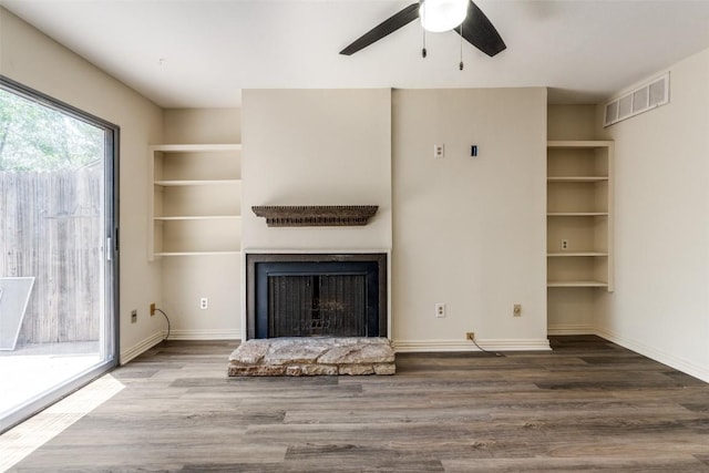 6910 Hart Ln Unit 807, Austin, TX 78731 - unfurnished living room with wood finished floors, ceiling fan, and a fireplace with raised hearth