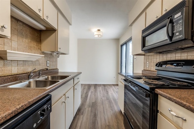 6910 Hart Ln Unit 807, Austin, TX 78731 - kitchen featuring black appliances, backsplash, wood finished floors, white cabinetry, and dark countertops