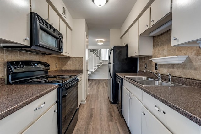 6910 Hart Ln Unit 807, Austin, TX 78731 - kitchen with black appliances, dark countertops, light wood-type flooring, and decorative backsplash