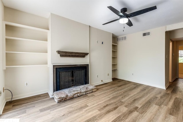 6910 Hart Ln Unit 807, Austin, TX 78731 - unfurnished living room featuring wood finished floors, a fireplace with raised hearth, and ceiling fan