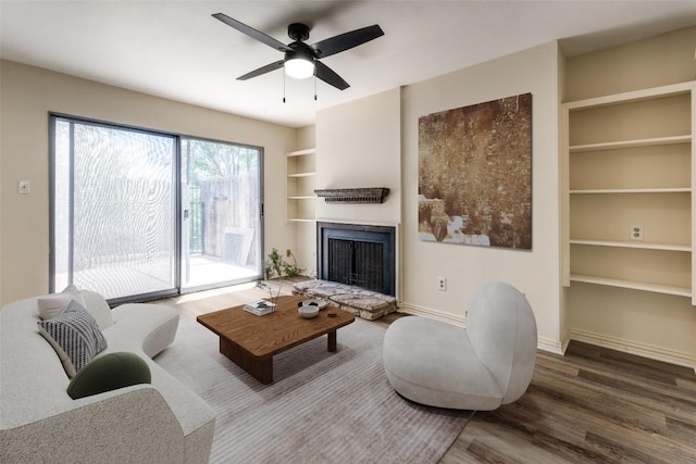 6910 Hart Ln Unit 807, Austin, TX 78731 - living room with built in features, wood finished floors, a fireplace with raised hearth, and ceiling fan