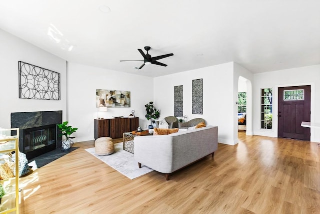 13305 Teton Ridge Cv, Austin, TX 78727 - living area featuring arched walkways, light wood-style floors, a fireplace, and ceiling fan