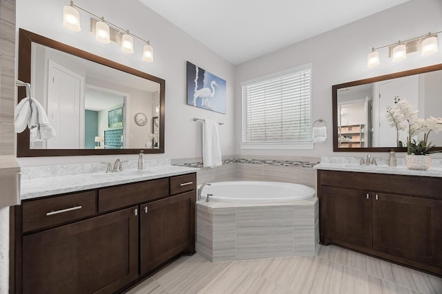 104 Atlanta Park Dr, Georgetown, TX 78628 - bathroom featuring two vanities, a garden tub, and tile patterned floors
