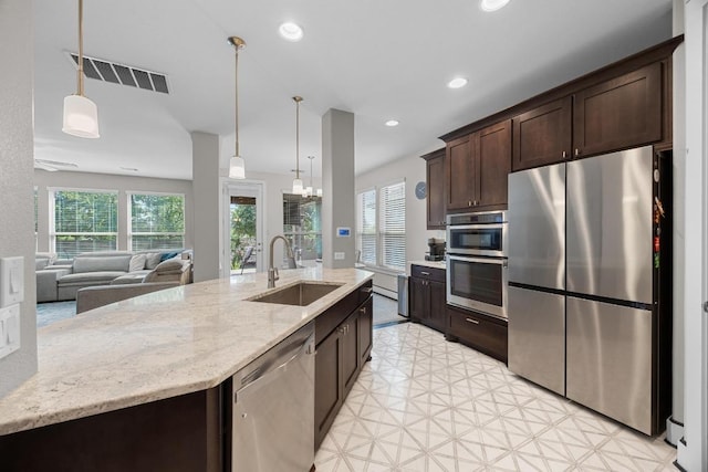 104 Atlanta Park Dr, Georgetown, TX 78628 - kitchen featuring stainless steel appliances, dark brown cabinetry, plenty of natural light, pendant lighting, and recessed lighting