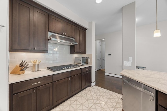 104 Atlanta Park Dr, Georgetown, TX 78628 - kitchen featuring under cabinet range hood, stainless steel appliances, light countertops, dark brown cabinets, and light floors