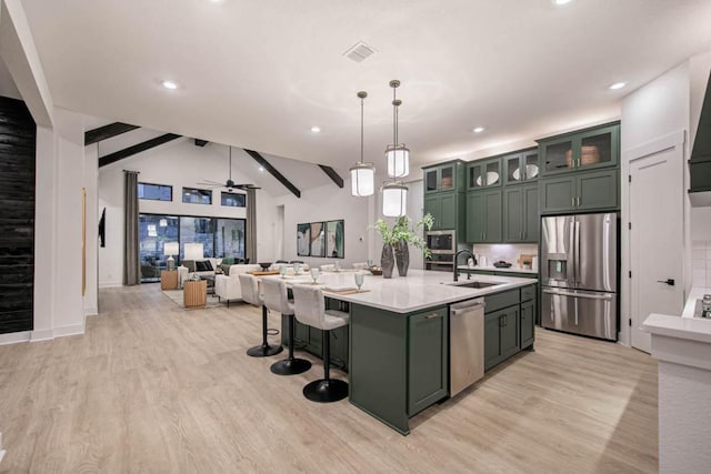 19125 Hopper Ln, Austin, TX 78738 - kitchen with stainless steel appliances, green cabinets, light wood finished floors, light countertops, and recessed lighting