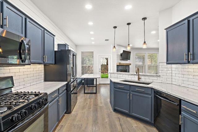 2208 Drue Ln, Cedar Park, TX 78613 - kitchen with black appliances, decorative backsplash, recessed lighting, wood finished floors, and a fireplace