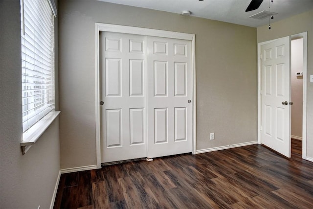 306 Grutsch Dr, Bastrop, TX 78602 - unfurnished bedroom with dark wood finished floors, a closet, and ceiling fan