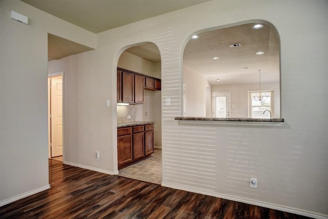 306 Grutsch Dr, Bastrop, TX 78602 - kitchen featuring wood finished floors, stone countertops, recessed lighting, arched walkways, and a chandelier