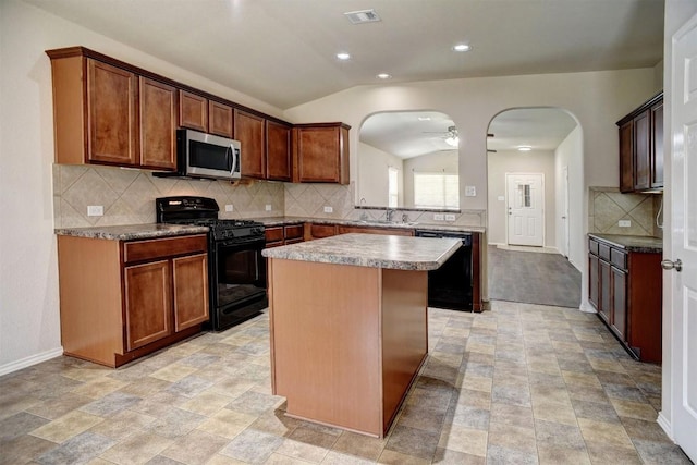 306 Grutsch Dr, Bastrop, TX 78602 - kitchen with black appliances, arched walkways, a kitchen island, decorative backsplash, and vaulted ceiling