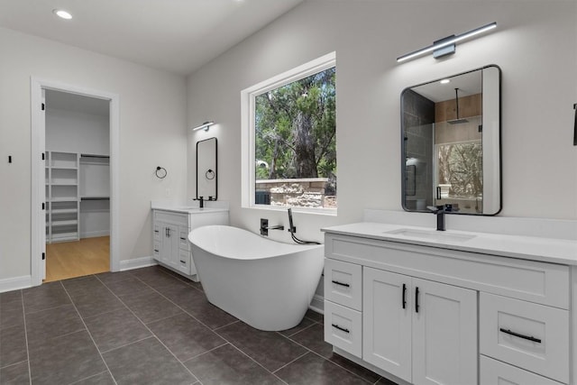 7705 Calcutta Run Dr, Jonestown, TX 78645 - full bathroom with a stall shower, two vanities, a freestanding bath, tile patterned floors, and a walk in closet