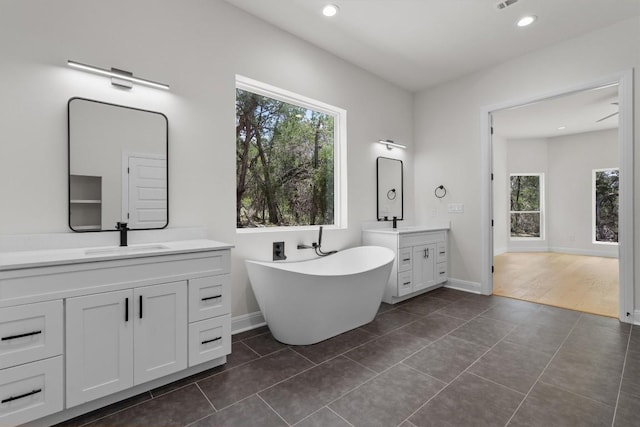 7705 Calcutta Run Dr, Jonestown, TX 78645 - full bathroom featuring two vanities, a soaking tub, tile patterned floors, and recessed lighting