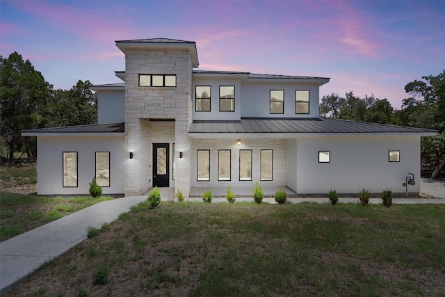 7705 Calcutta Run Dr, Jonestown, TX 78645 - view of front of home with a standing seam roof, a metal roof, and a lawn