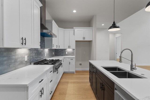 7705 Calcutta Run Dr, Jonestown, TX 78645 - kitchen featuring wall chimney exhaust hood, appliances with stainless steel finishes, recessed lighting, light wood-type flooring, and pendant lighting