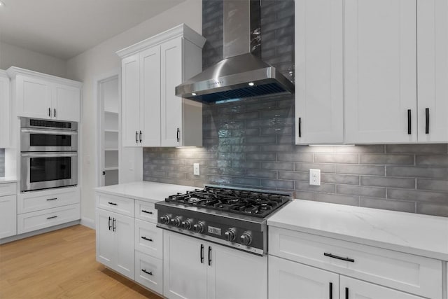 7705 Calcutta Run Dr, Jonestown, TX 78645 - kitchen featuring wall chimney exhaust hood, gas stovetop, double oven, white cabinetry, and backsplash