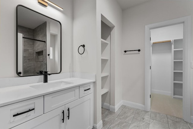 7705 Calcutta Run Dr, Jonestown, TX 78645 - bathroom with a walk in closet, vanity, and a tile shower