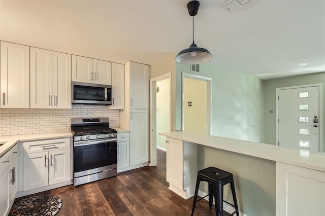 1610 Broadmoor Dr, Austin, TX 78723 - kitchen featuring stainless steel appliances, tasteful backsplash, light countertops, dark wood finished floors, and white cabinetry