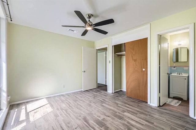 1610 Broadmoor Dr, Austin, TX 78723 - unfurnished bedroom featuring wood finished floors, a closet, connected bathroom, and ceiling fan
