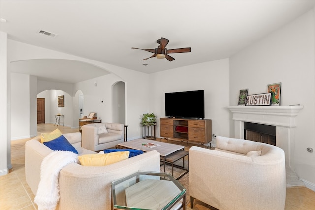3308 Harvest Time Cv, Austin, TX 78754 - living room featuring arched walkways, a ceiling fan, a fireplace, and light tile patterned flooring