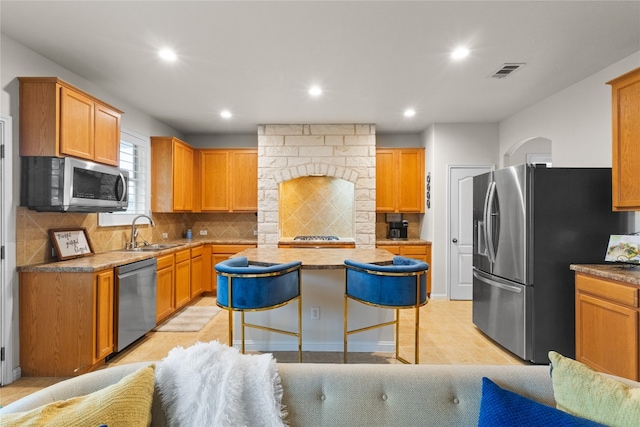 3308 Harvest Time Cv, Austin, TX 78754 - kitchen featuring appliances with stainless steel finishes, a center island, recessed lighting, decorative backsplash, and a breakfast bar area
