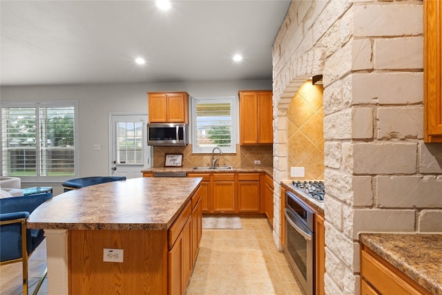 3308 Harvest Time Cv, Austin, TX 78754 - kitchen featuring appliances with stainless steel finishes, backsplash, a kitchen island, plenty of natural light, and recessed lighting