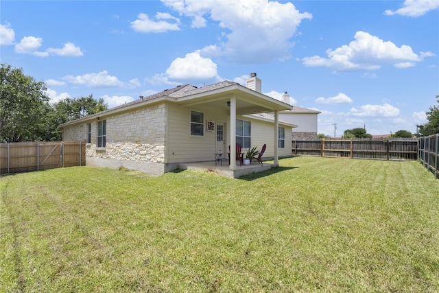 3308 Harvest Time Cv, Austin, TX 78754 - back of house with a patio, a chimney, a fenced backyard, and stone siding