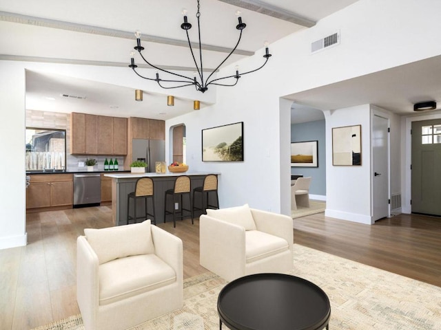5314 Presidio Rd, Austin, TX 78745 - living area with light wood-style flooring, a chandelier, arched walkways, and beamed ceiling