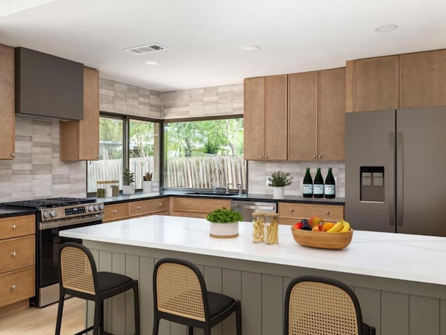5314 Presidio Rd, Austin, TX 78745 - kitchen with appliances with stainless steel finishes, a kitchen bar, decorative backsplash, and brown cabinets