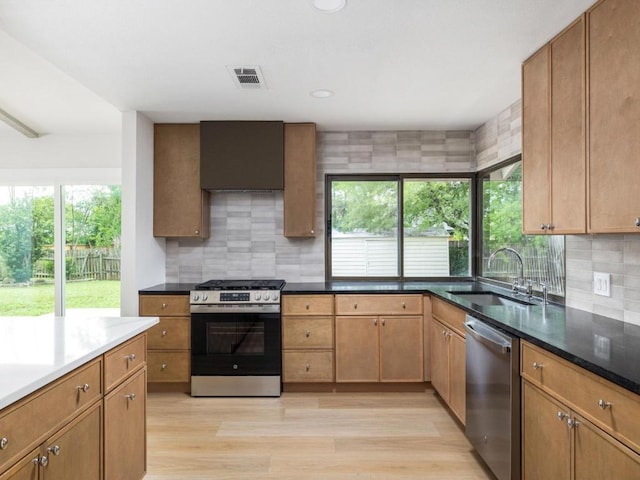5314 Presidio Rd, Austin, TX 78745 - kitchen with appliances with stainless steel finishes, light wood finished floors, tasteful backsplash, recessed lighting, and custom range hood
