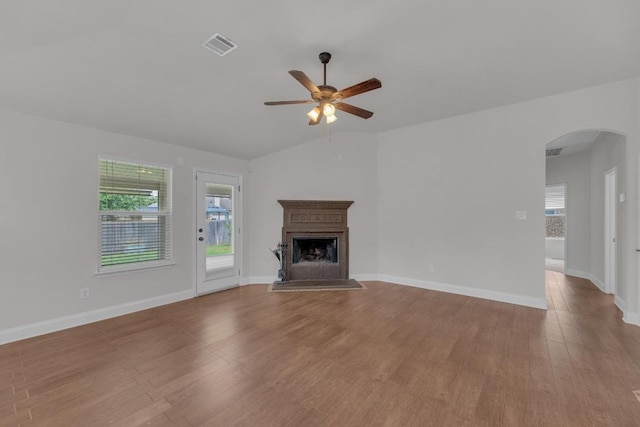 109 Inman Dr, Hutto, TX 78634 - unfurnished living room featuring arched walkways, a ceiling fan, wood finished floors, and plenty of natural light