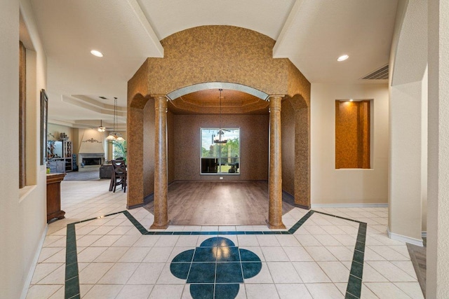 106 Mesquite Trl, Boerne, TX 78006 - foyer featuring ornate columns, a tray ceiling, inlaid floor details, arched walkways, and ornamental molding
