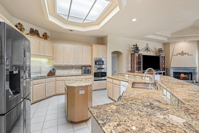 106 Mesquite Trl, Boerne, TX 78006 - kitchen with appliances with stainless steel finishes, a large island with sink, a raised ceiling, decorative backsplash, and light tile patterned floors
