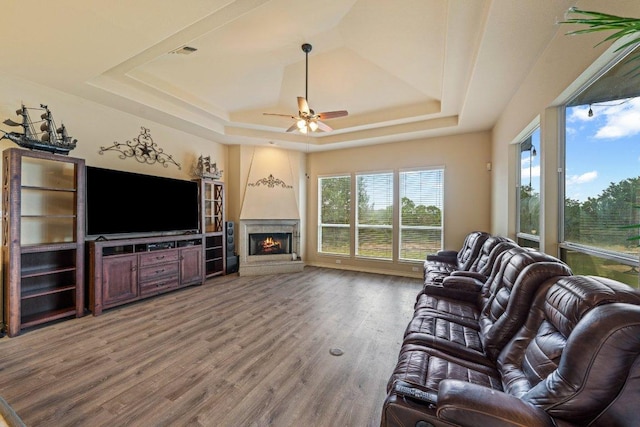 106 Mesquite Trl, Boerne, TX 78006 - living area featuring a raised ceiling, ceiling fan, wood finished floors, and a lit fireplace