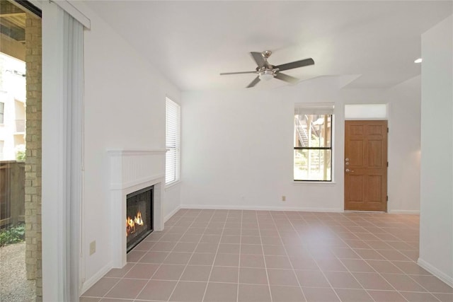 611 E 45th St Unit 8, Austin, TX 78751 - unfurnished living room with a glass covered fireplace, a ceiling fan, and tile patterned floors