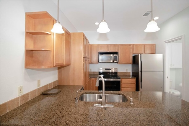 611 E 45th St Unit 8, Austin, TX 78751 - kitchen with stainless steel appliances, pendant lighting, dark stone counters, and a peninsula